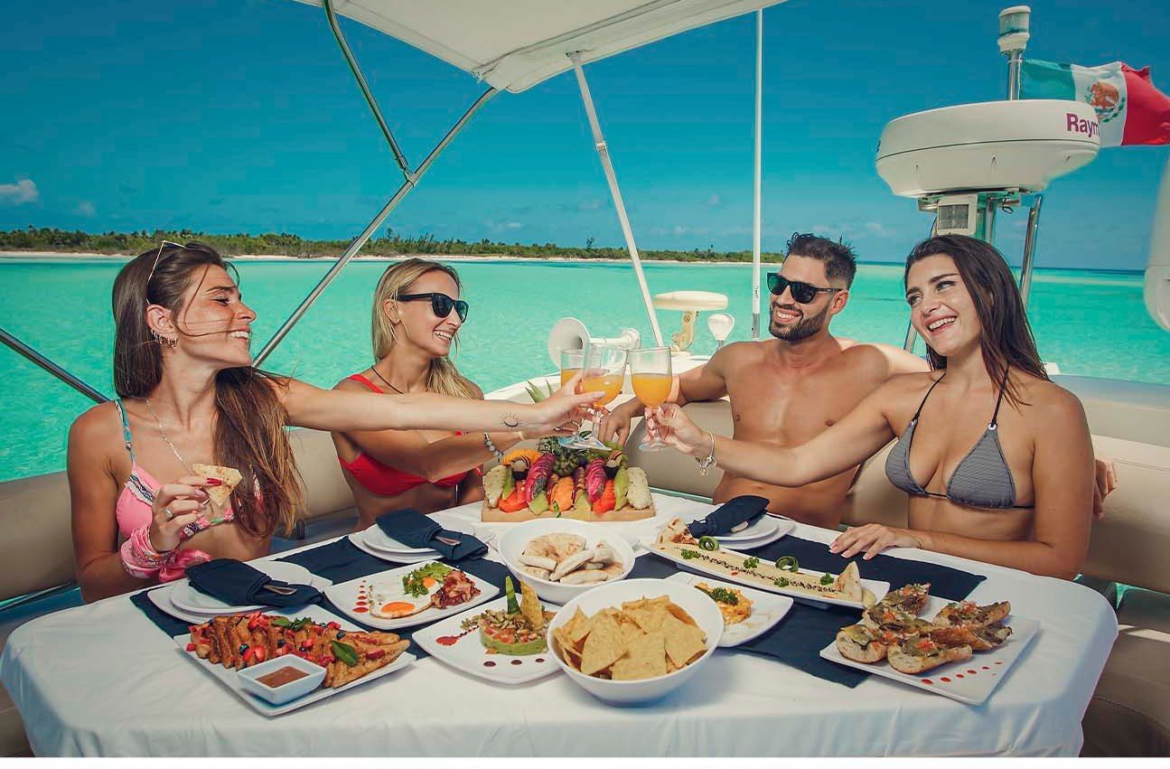 Guests toasting over a gourmet lunch spread on the yacht's shaded deck