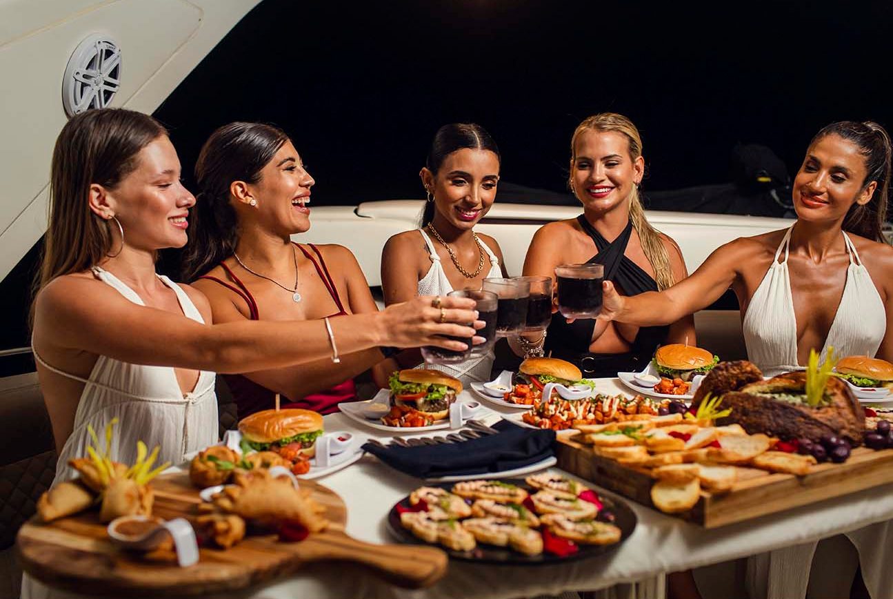 Friends celebrating around an abundant dinner table onboard at night